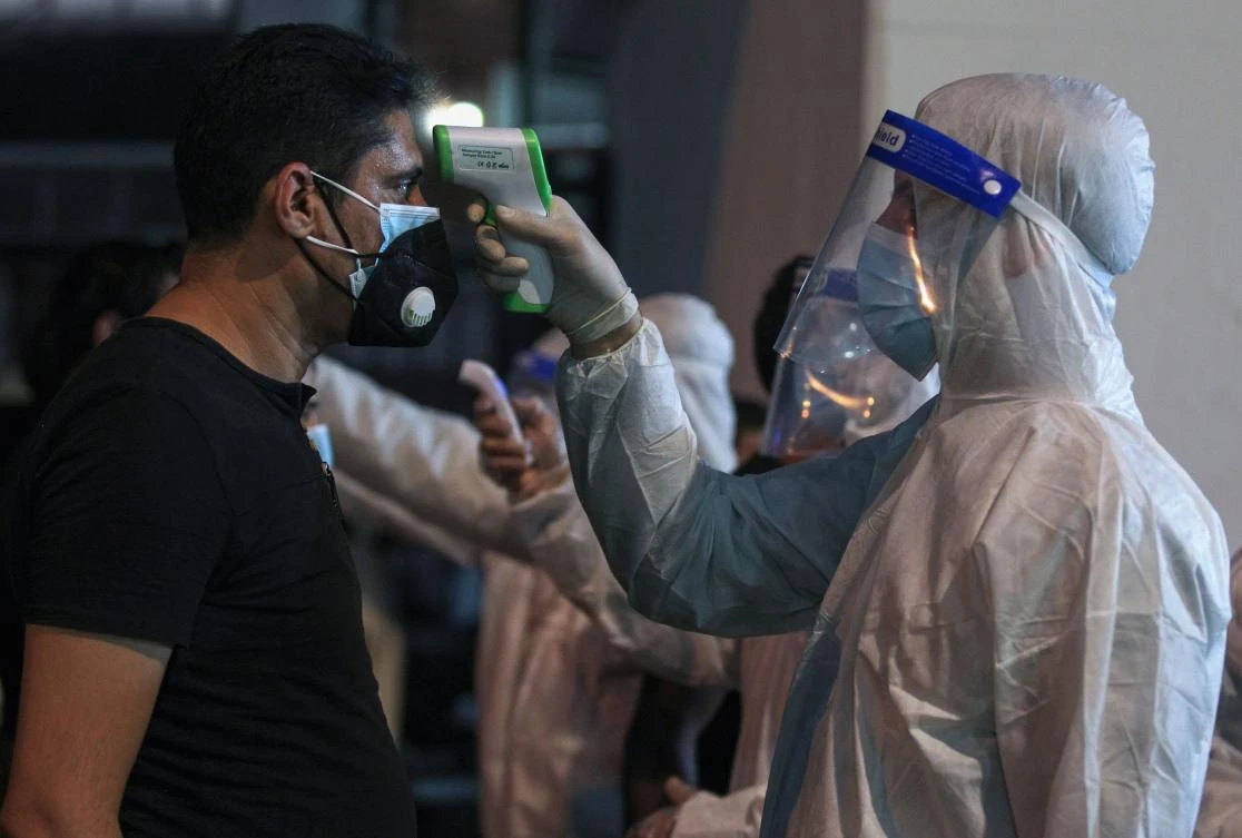 Iraqi Shiite Muslim men get their temperature checked amid the COVID-19 pandemic, as they arrive to participate in Ashura commemorations at the headquarters of Shiite Muslim leader and head of Hikma party Ammar Al-Hakim, in the capital Baghdad. (AFP)
