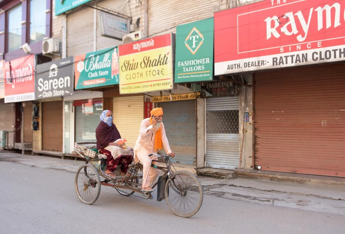 A rickshaw puller rides along a street past closed shops after strict lockdown norms for weekends and public holidays were imposed as a preventive measure against the COVID-19 coronavirus, in Amritsar on August 22, 2020. (AFP)