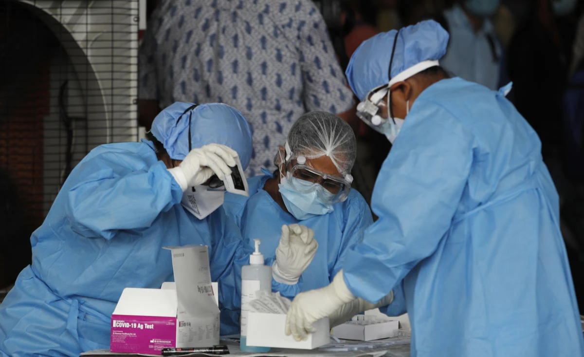 Health workers conduct COVID-19 antigen tests for migrant workers in New Delhi, India, Aug. 18, 2020. In June, India began using the cheaper, faster but less accurate tests to scale up testing for the coronavirus — a strategy that the US is now considering. (AP)