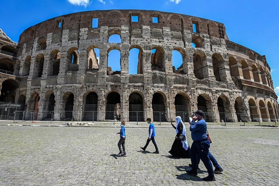 Tourists walk on June 22, 2020 by the Coliseum monument in Rome, as the country eases its lockdown aimed at curbing the spread of the COVID-19 infection, caused by the novel coronavirus. (File/AFP)