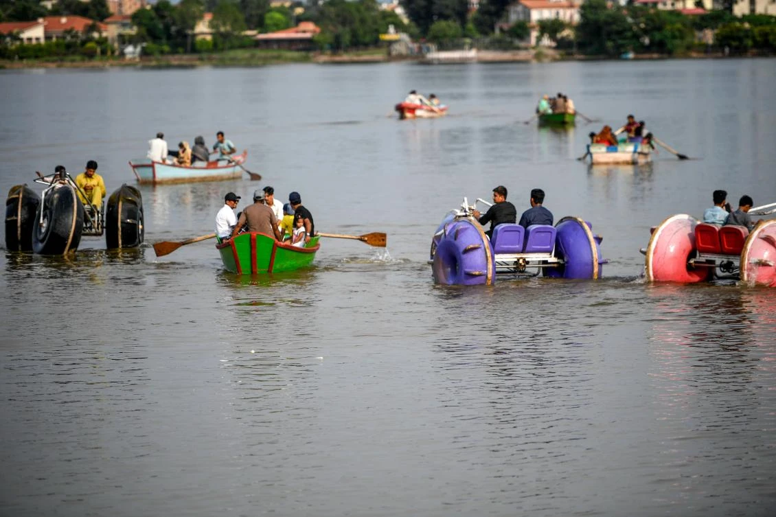 Tourists ride water-tricycles and boats at the Rawal Lake in Islamabad on August 19, 2020, after the government announced most of the country's remaining restrictions would be lifted following the drop in new COVID-19 coronavirus cases for several weeks. (AFP)