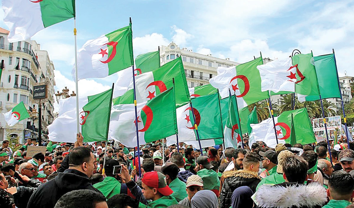 Demonstrators carry national flags during a 2019 protest in Algiers. The country’s hydrocarbon-dependent economy is in an extremely fragile state. (Reuters/File)
