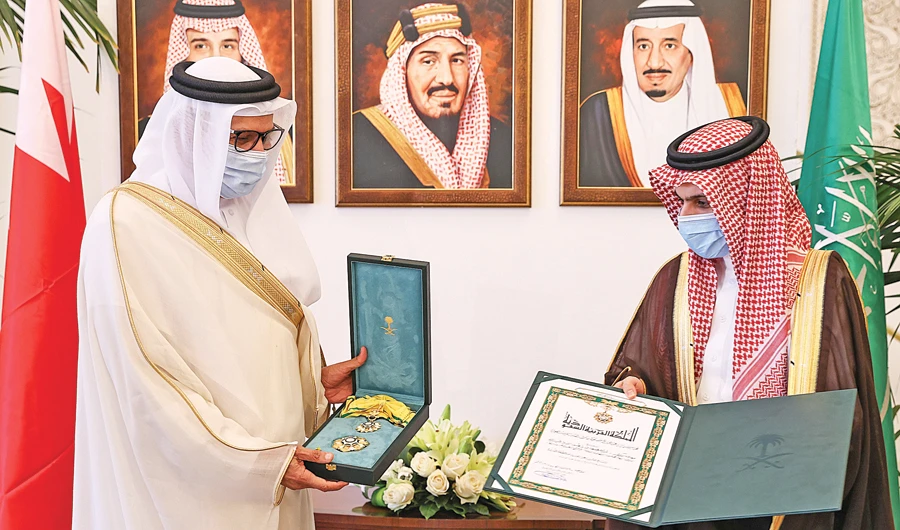 Saudi Foreign Minister Prince Faisal bin Farhan, right, presents his Bahraini counterpart the King Abdul Aziz Sash of the second degree in Riyadh. (SPA)