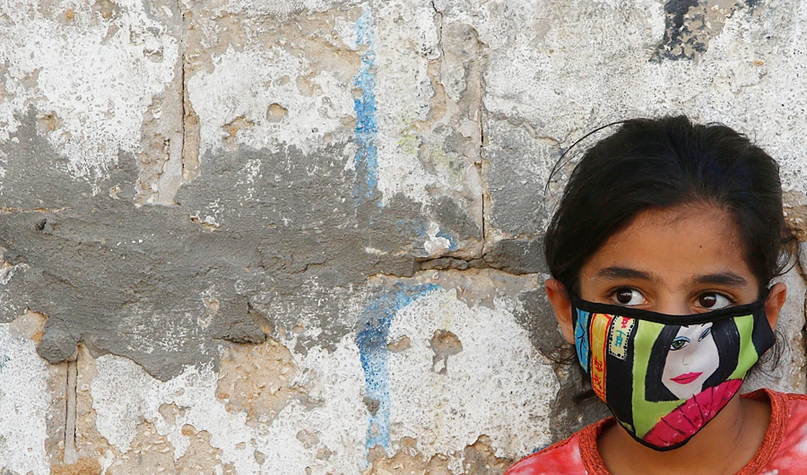 A Palestinian girl wear a face mask during a lockdown imposed following the discovery of coronavirus cases in the Gaza Strip, on Thursday. (AP)