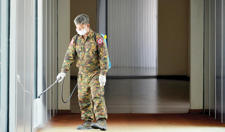A member of Myanmar’s military sprays disinfectant as a preventive measure to contain the spread of COVID-19 infection at Naypyidaw International Airport in Naypyidaw. (AFP/File)