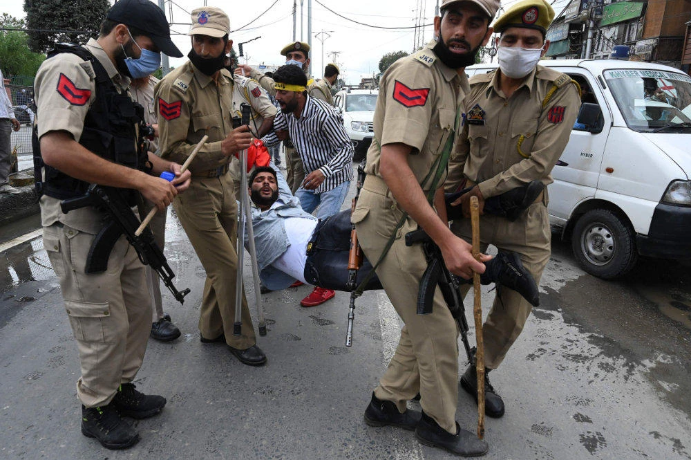 Indian policemen detain a Kashmiri Shiite Muslims as he and others attempt to take out a religious procession in Srinagar, Indian-controlled Kashmir, on Aug. 28, 2020. (AP Photo/Mukhtar Khan)