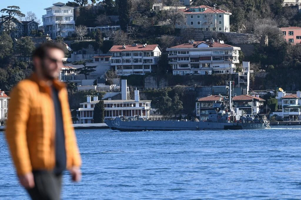 A man walks beside the waters of The Bosphorus Strait in Istanbul on February 13, 2020, as Turkish Navy C140 landing ship sails. (AFP file photo)