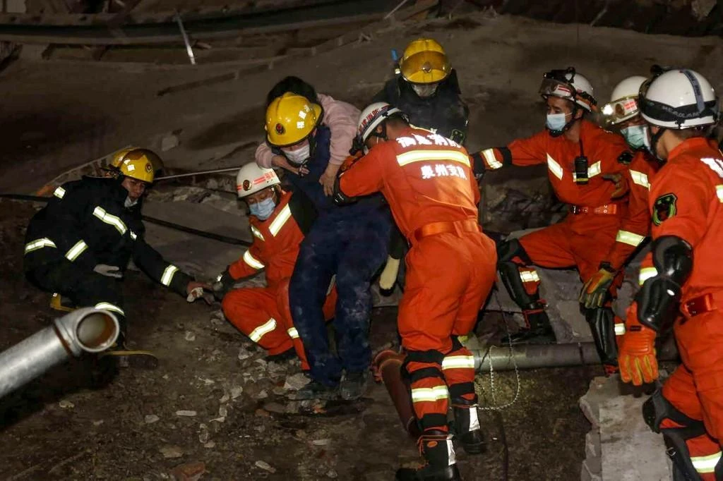A woman (on the back) is rescued from the rubble of a collapsed hotel in Quanzhou, in China's eastern Fujian province on March 7, 2020. (File/AFP)