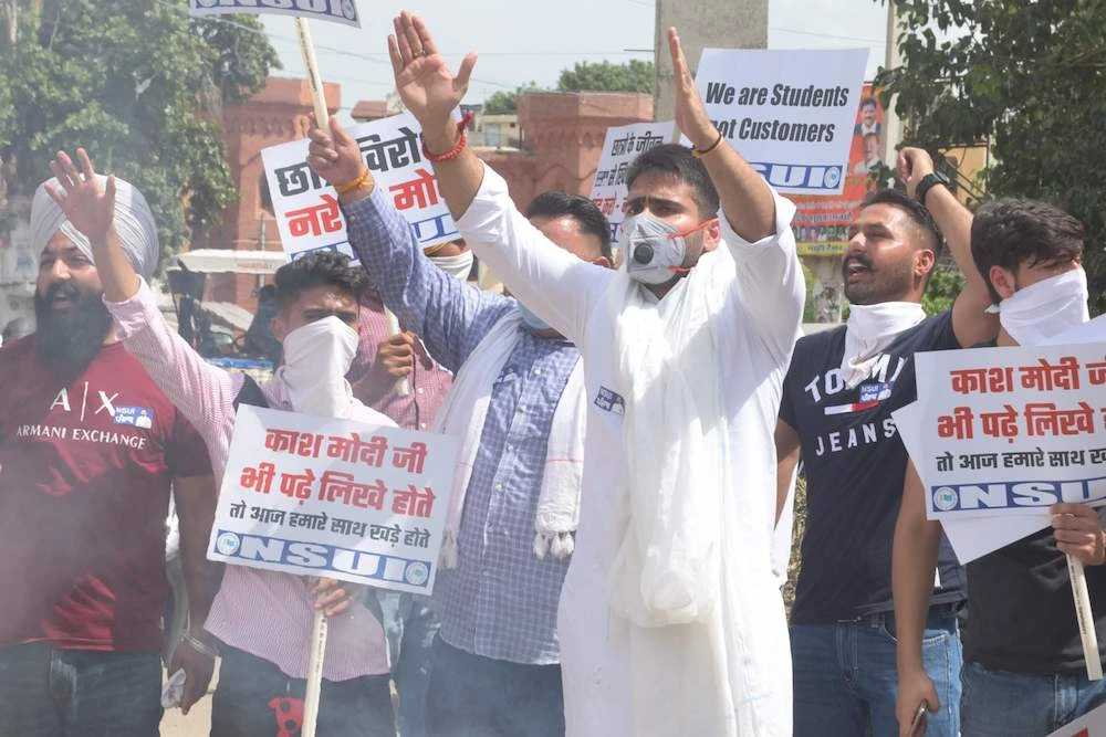 Activists of National Students Union of India (NSUI) shout slogans during a protest against the central government led by Narendra Modi and the Union Education Minister Ramesh Pokhriyal to demand the waiver of one semester's fee and postponement of exams in all states due to the Covid-19 pandemic outside the Bharatiya Janata Party (BJP) office, in Amritsar. (AFP)