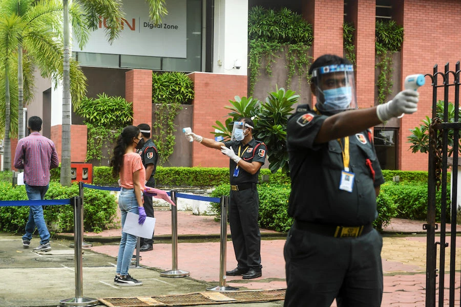 Private security guards check the body temperature of students prior to their entry for the entrance examination of the Banaras Hindu University (BHU). (AFP)