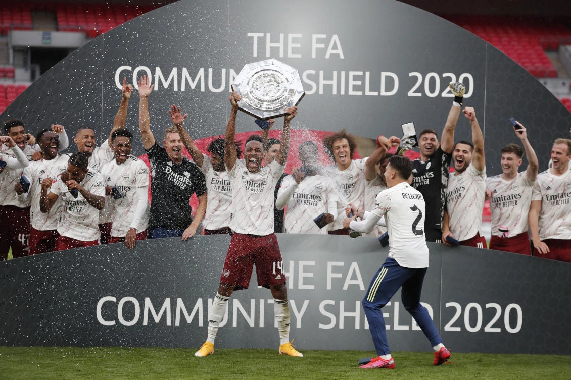 Arsenal's Hector Bellerin sprays champagne at Pierre-Emerick Aubameyang as he celebrates with the trophy after winning the FA Community Shield. (Reuters)