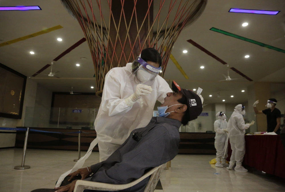 A health worker takes a nasal swab sample to test for COVID-19 at a state bus station in Ahmedabad, India, on Aug. 29, 2020. India has the third-highest coronavirus caseload after the United States and Brazil, and the fourth-highest death toll in the world. (AP Photo/Ajit Solanki)