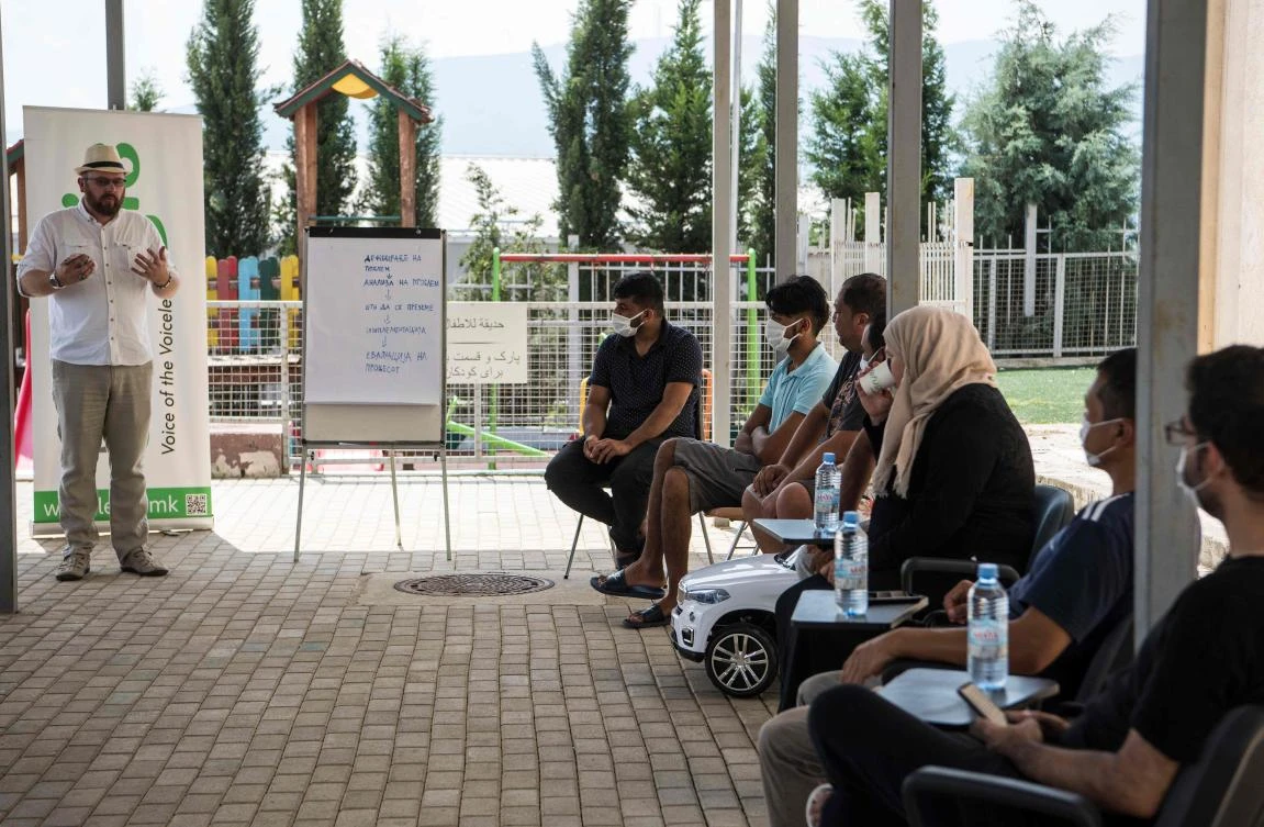 Jasmin Redjepi from NGO Legis gives a lecture to migrants who seek asylum in a migrant center near Skopje on August 15, 2020. (AFP)