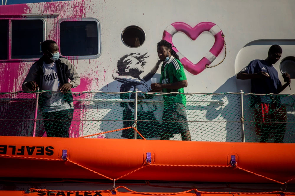 Italian coast guard in mission to save 200 migrants stranded on ‘Banksy’ rescue boat