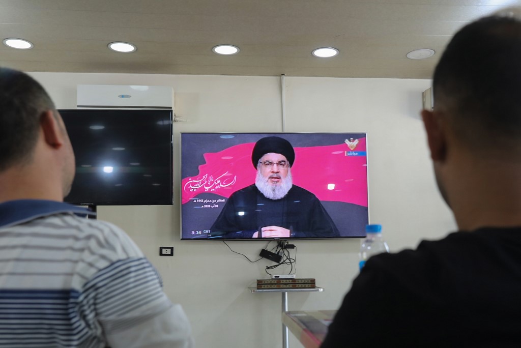 Residents watch the head of Lebanon’s Shiite Muslim movement Hezbollah Hassan Nasrallah during a televised speech on August 30, 2020. (AFP file photo)