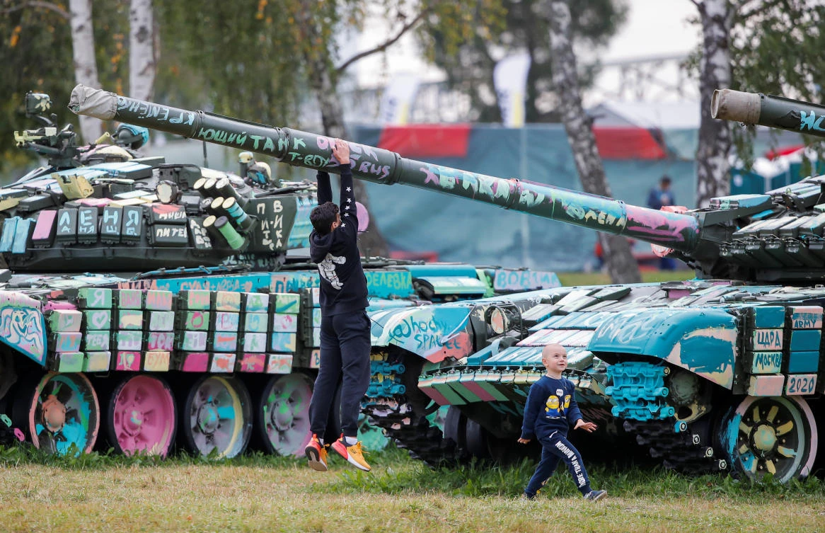 A boy hangs on the tank barrel during the Tank Biathlon competition at the International Army Games 2020 in Alabino, outside Moscow, Russia September 2, 2020. REUTERS/Maxim Shemetov