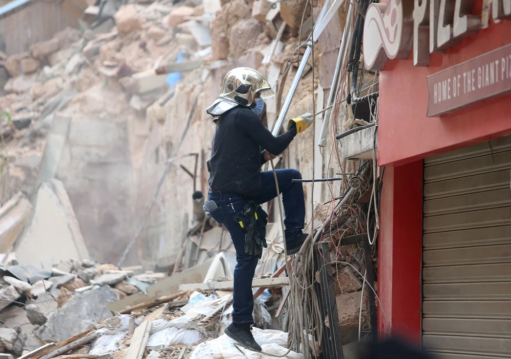 A rescue team member searches through rubble of a building in Beirut for possible survivors. (Reuters)