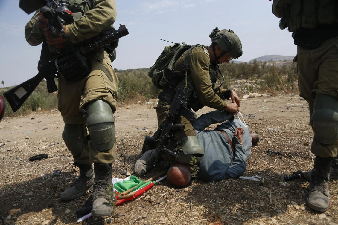 Israeli soldiers detain a Palestinian during a protest against expansion of Israeli settlements in the village of Shufa in the West Bank, Tuesday, Sep. 1, 2020.(AP)