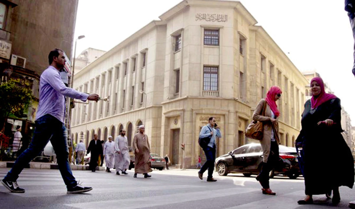 Egyptians walk in front of the Egyptian Central Bank in Cairo. (AP)