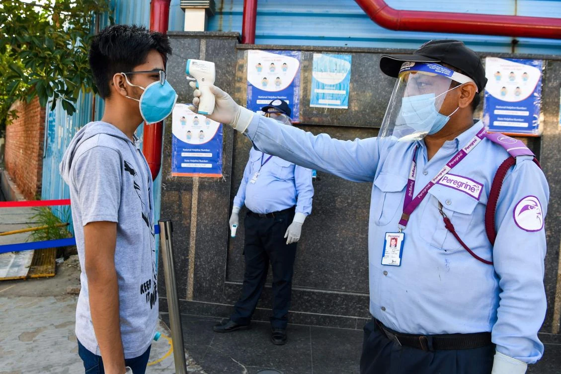A student gets his temperature taken as he arrives at an examination centre for Joint Entrance Examination (JEE ) Main-2020 in Noida on September 1, 2020. (AFP)