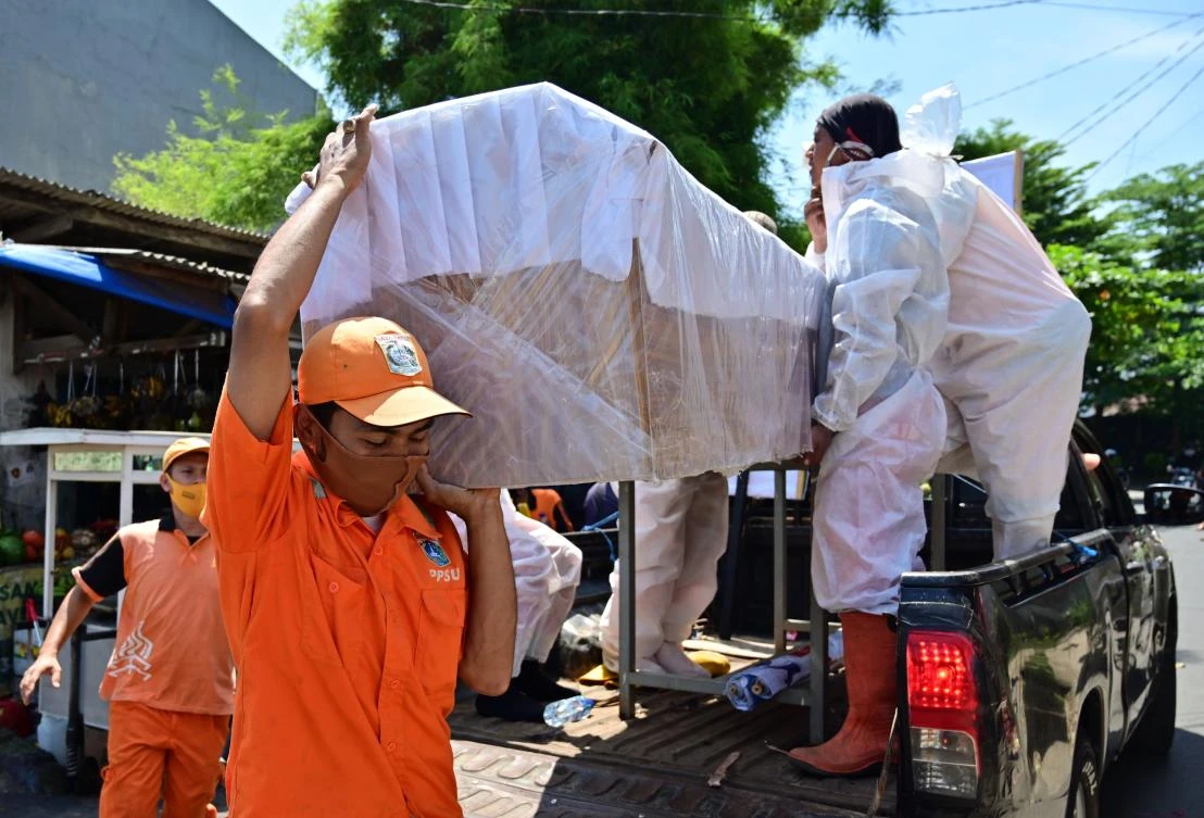 Workers load a mock coffin onto a pickup truck as part of an awareness drive against the COVID-19 in Jakarta on September 1, 2020. (AFP)