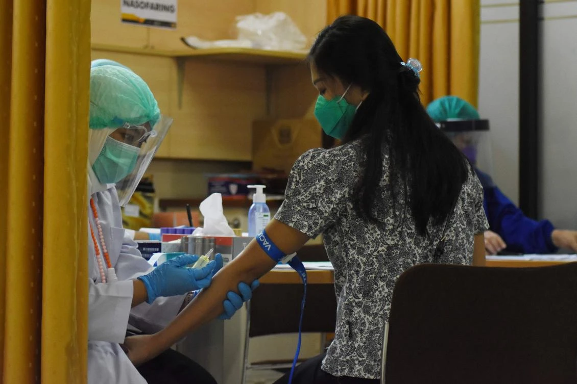 A volunteer has her blood samples taken before she receives COVID-19 coronavirus vaccine as part of a clinical trial at the Padjadjaran University educational hospital in Bandung, West Java. (AFP)