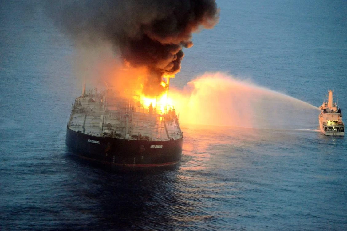 This handout photograph taken on September 4, 2020 shows an Indian coast guard ship (R) battling to extinguish the fire from the Panamanian-registered crude oil tanker New Diamond, some 60 km off Sri Lanka's eastern coast. (AFP)