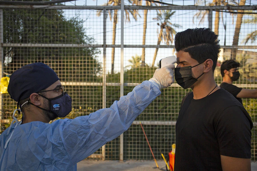 An Iraqi worshipper has his temperature measured at the entrance of a mosque on August 20, 2020, as Muslim Shiites start marking Ashura under new health guidelines to limit the risk of exposure to Covid-19 virus. (AFP)