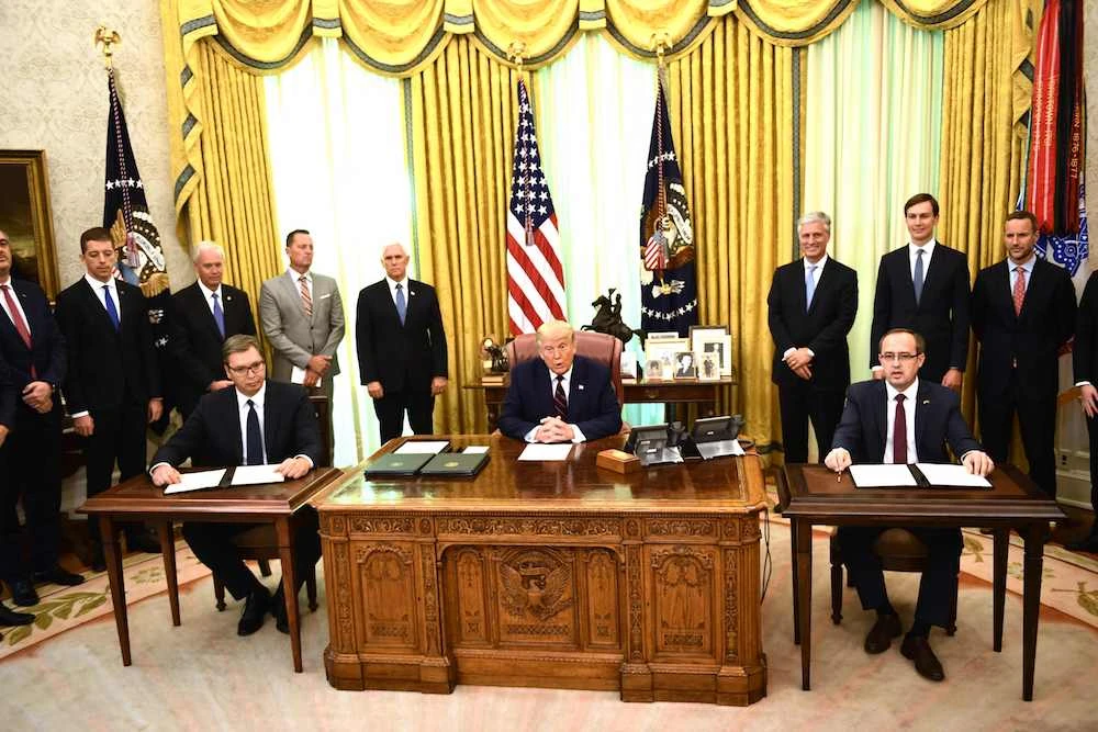 US President Donald Trump speaks before Kosovar Prime Minister Avdullah Hoti (R) and Serbian President Aleksandar Vucic (L) sign an agreement on opening economic relations, in the Oval Office of the White House. (AFP)
