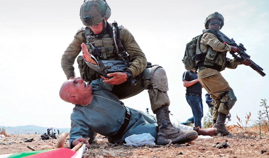 Israeli soldiers hold a Palestinian protester during a demonstration against the Israeli settlement plan, in Tulkarm in the occupied West Bank. (AFP)