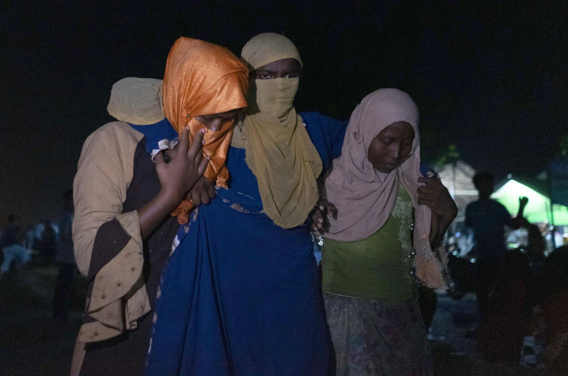 An ethnic Rohingya woman is assisted to walk by others after the boat carrying them landed in Lhokseumawe, Aceh province, Indonesia, early Monday, Sept. 7, 2020. Almost 300 Rohingya Muslims were found on a beach in Indonesia's Aceh province Monday and were evacuated by military, police and Red Cross volunteers, authorities said. (AP)