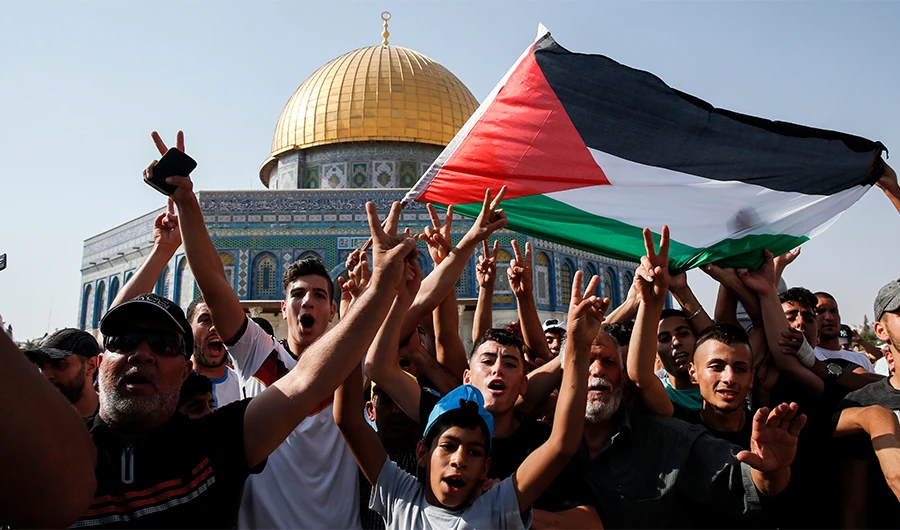 Palestinian Muslims wave a national flag and flash the victory gesture in front of the Dome of the Rock in the Haram al-Sharif compound, known to Jews as the Temple Mount, in the old city of Jerusalem on July 27, 2017. (AFP)