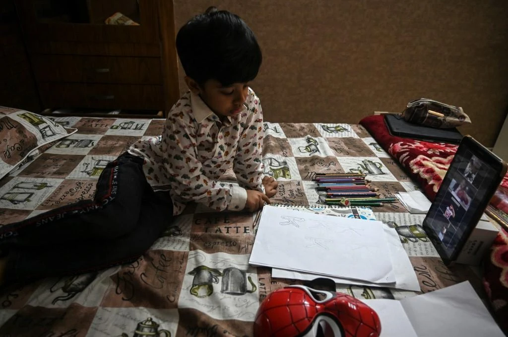 Above, Mohammad Ibrahim attends an online class at his home, while schools are closed, during a government-imposed nationwide lockdown in Islamabad on April 14, 2020. (AFP file photo)