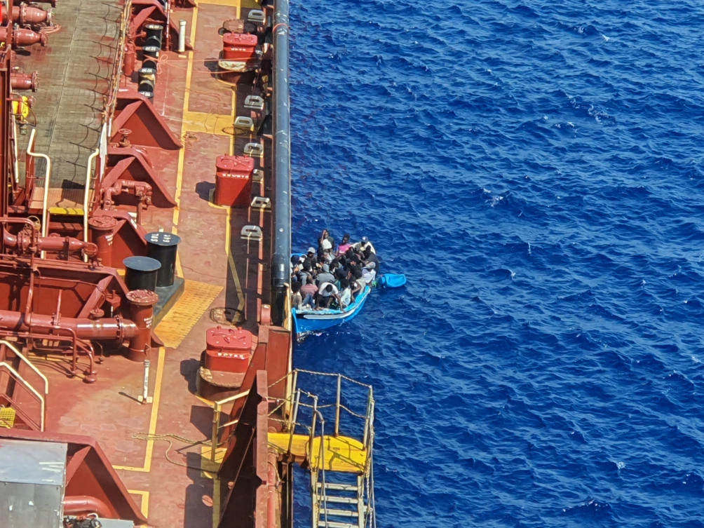 FILE PHOTO: Migrants sit in a boat alongside the Maersk Etienne tanker off the coast of Malta, in this handout image provided August 19, 2020. (Reuters)