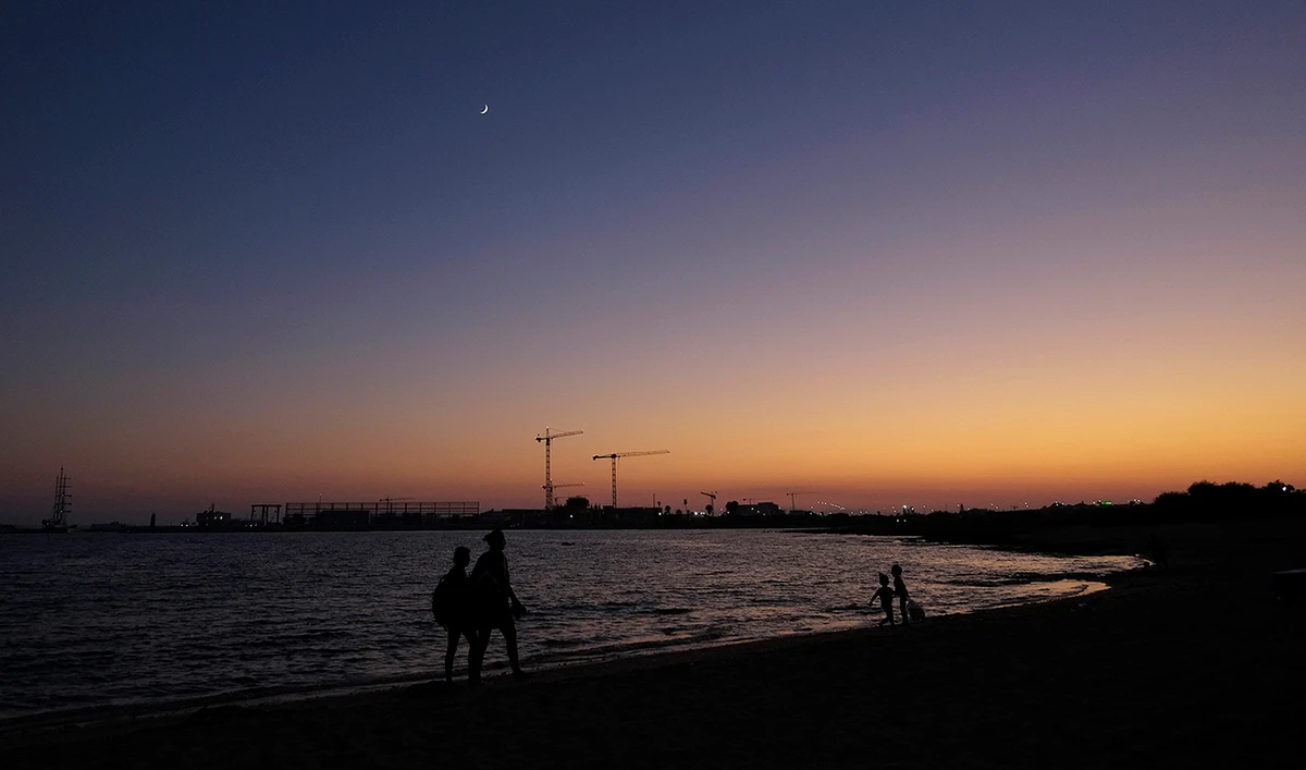People walk along the beach in the eastern Mediterranean island of Cyprus. (AP)
