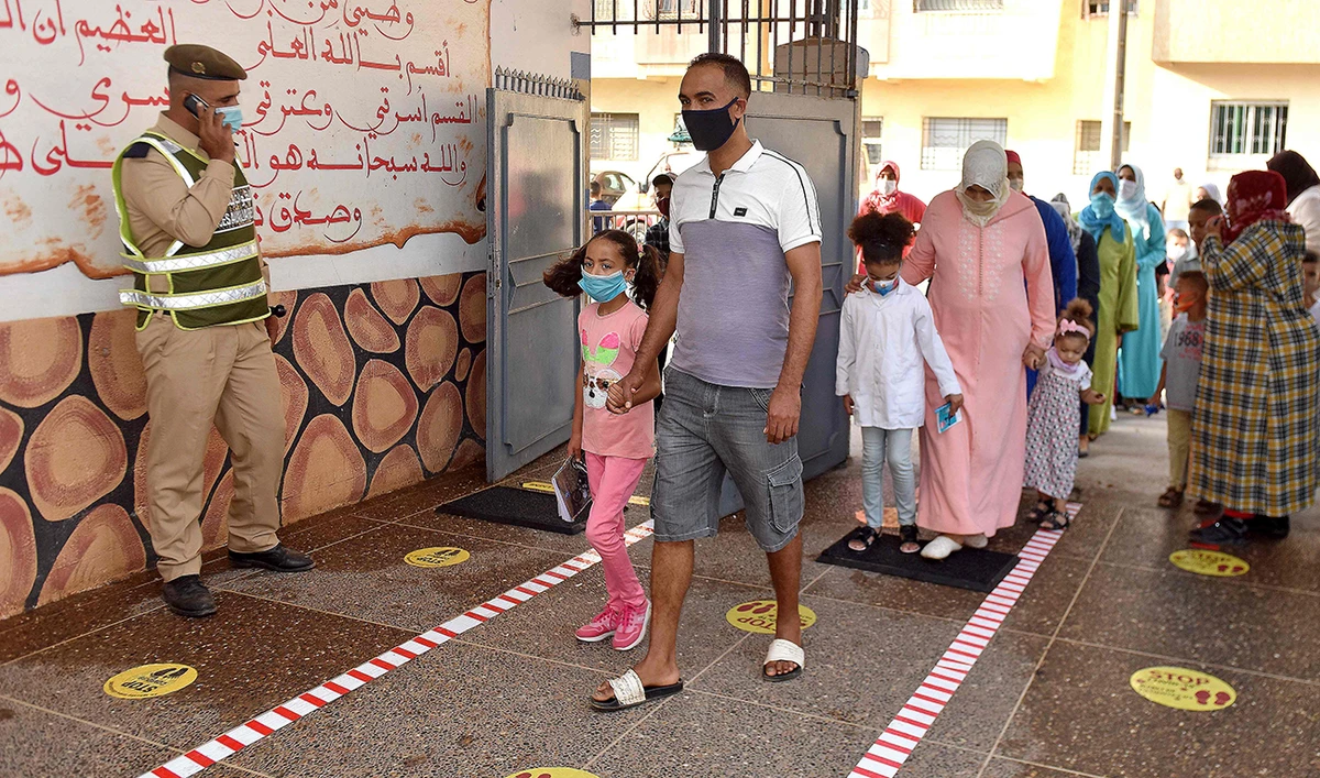 Parents accompany children to school on the first day of classes amid measures put in place by Moroccan authorities in bid to stop the spread of Covid-19, in the city of Sale on September 7, 2020. (AFP)