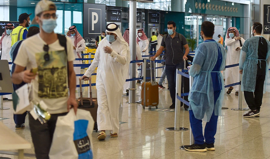 Saudi passengers queue for a temperature check at terminal 5 in the King Fahad International Airport, designated for domestic flights, in the capital Riyadh on May 31, 2020, after authorities lifted the ban on flights within the country. (AFP)