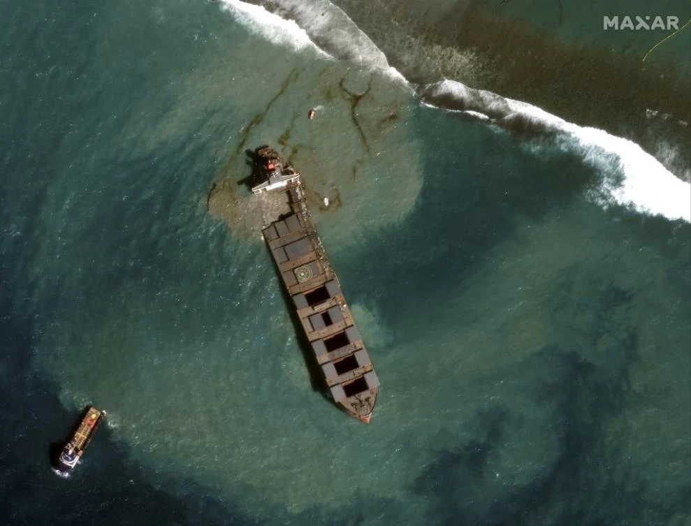 An image obtained courtesy of Maxar Technologies shows a close up view of the MV Wahashio shipwreck and tugs being towed away from the reef off the coast of Mauritius. (File/AFP)