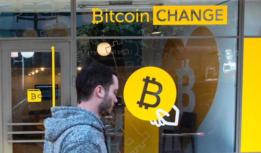 An Israeli walks past the cryptocurrency "Bitcoin Change" shop in the Israeli city of Tel Aviv on January 17, 2018. (AFP)