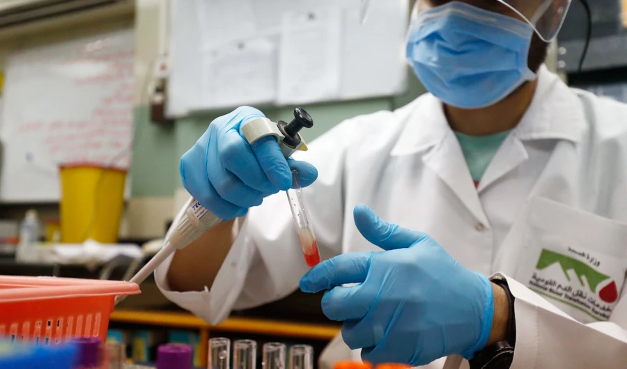 An Egyptian medical worker checks the blood of a man who recovered from Covid-19 at the National Blood Transfusion centre in Cairo on July 22, 2020. (AFP)