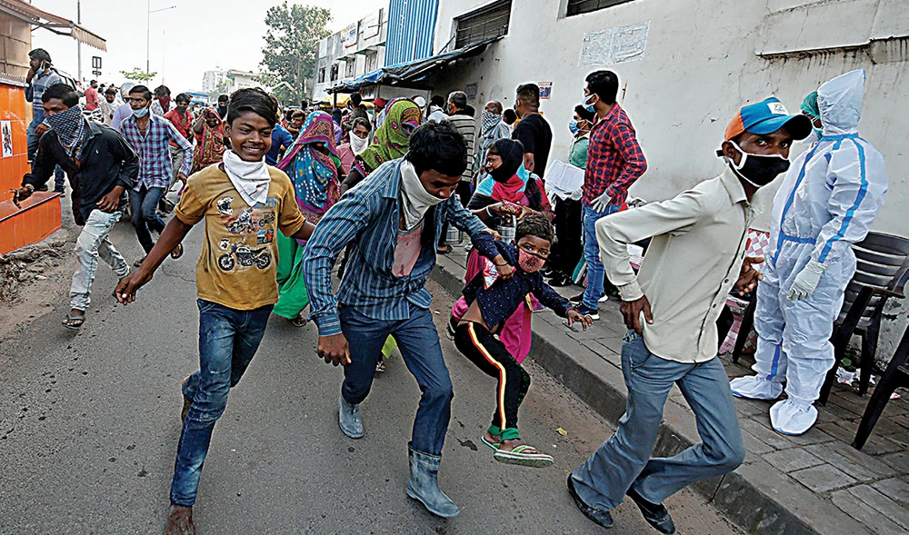 Migrant labourer looking for work are chased away by police for not following anti-coronavirus social distancing measures imposed in Ahmedabad, India. (Reuters)