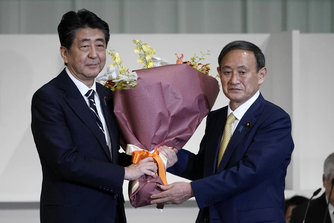 Japan ruling party head Yoshihide Suga preparing cabinet, continuity in foreground