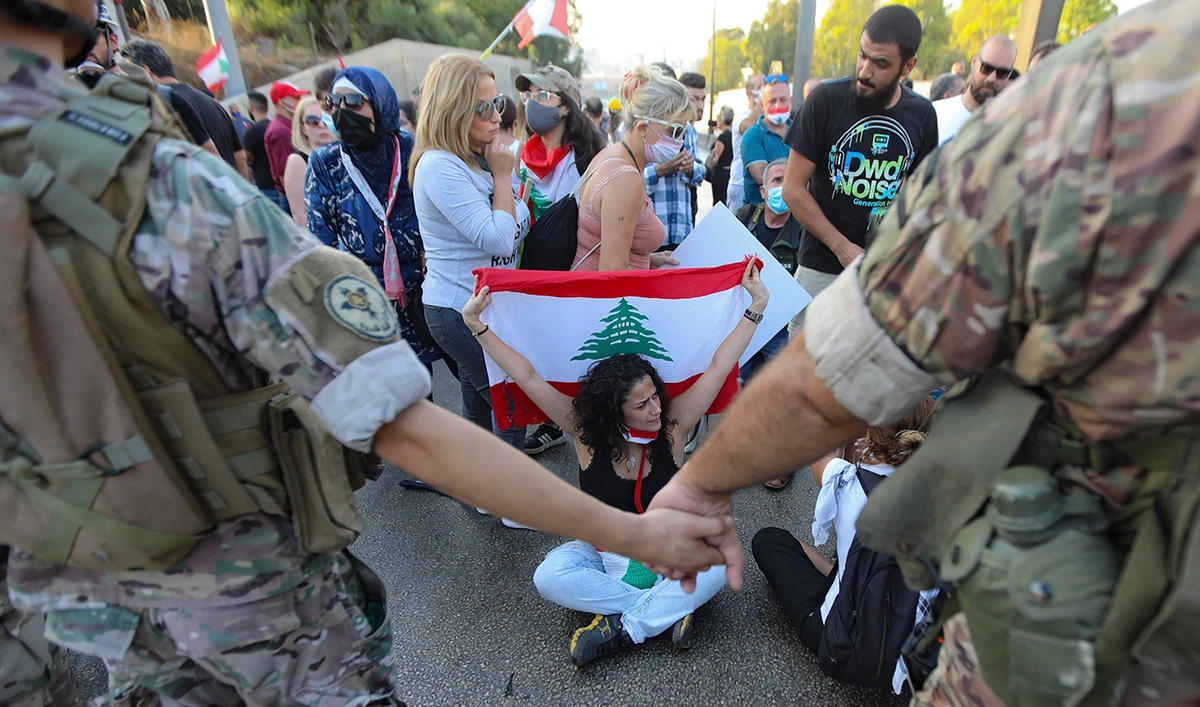Lebanese protesters face members of the security forces during a demonstration near the presidential palace in Baabda, east of the capital Beirut. (AFP)