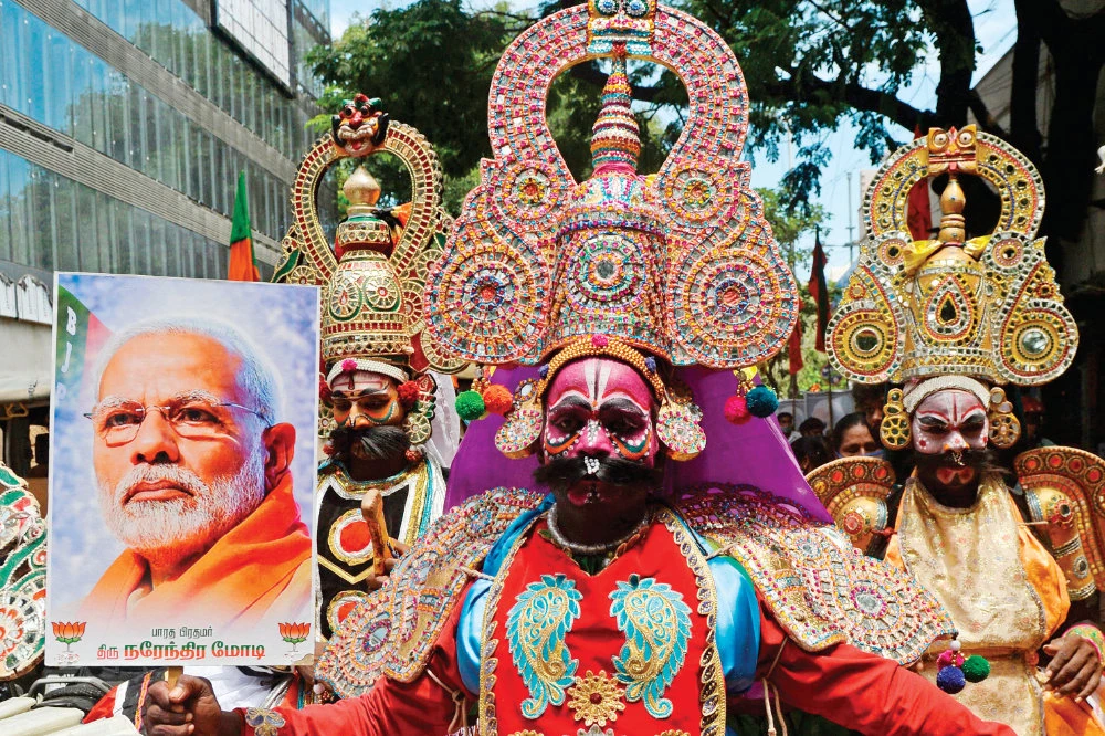 A ‘Therukoothu’ folk artist holds a placard with the image of Indian Prime Minister Narendra Modi during BJP celebrations for Modi’s 70th birthday, in Chennai on Thursday. (AFP)