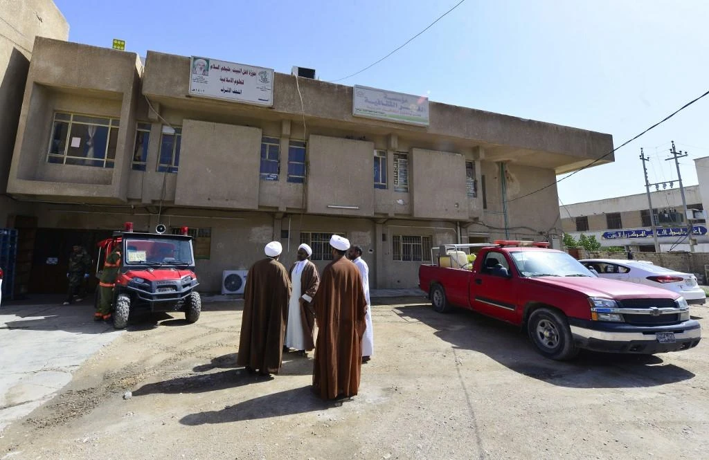 Clerics stand outside the building of a religious school which attracts predominantly foreign students. (File/AFP)