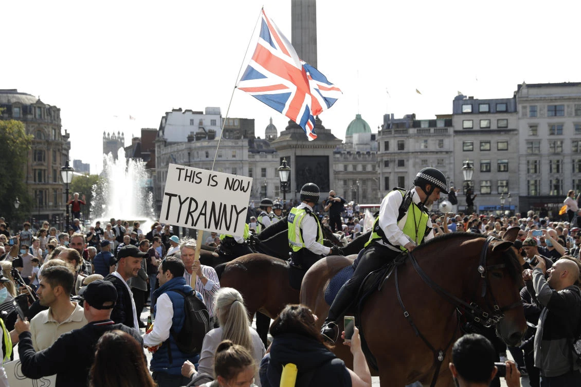 Police officers on horse-back stand next to protesters during a "Resist and Act for Freedom" protest against a mandatory coronavirus vaccine, wearing masks, social distancing and a second lockdown, in Trafalgar Square, London, Saturday, Sept. 19, 2020. (AP/Matt Dunham)