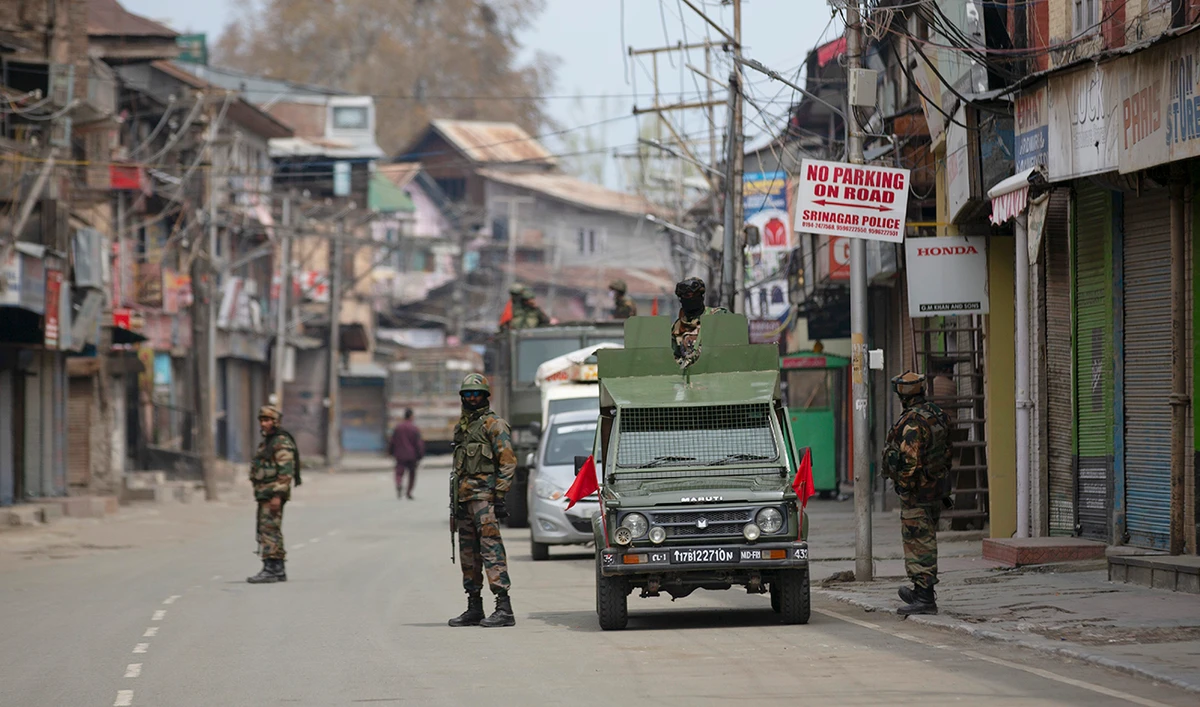 Indian army soldiers stand guard while they wait for a fellow soldier shopping during lockdown in Srinagar, Indian controlled Kashmir. (AP/File)