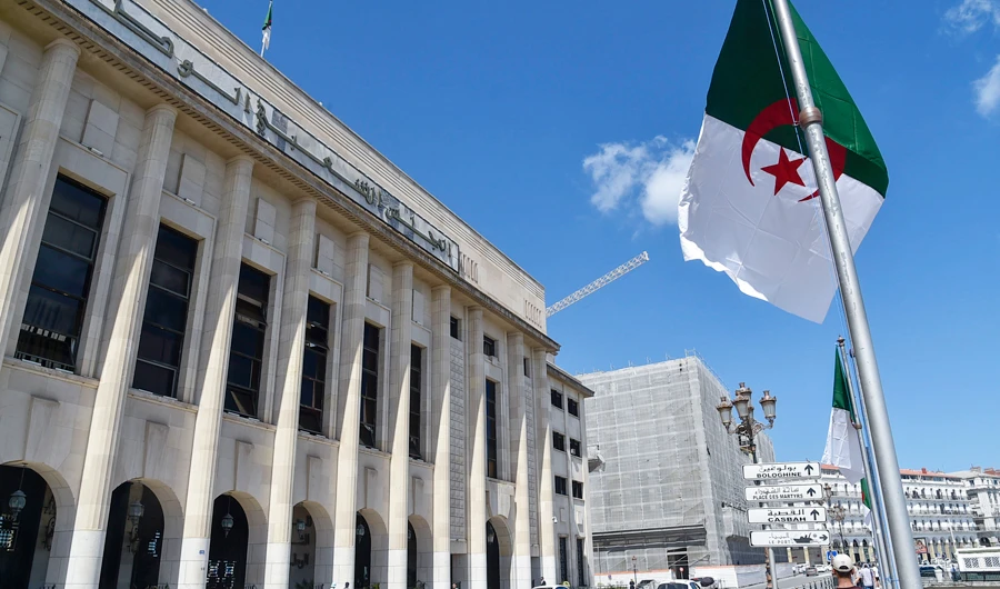 Algerians walk across from the People's National Assembly (parliament) building during a voting session on constitutional reforms in the capital Algiers, on September 10, 2020. (AFP)
