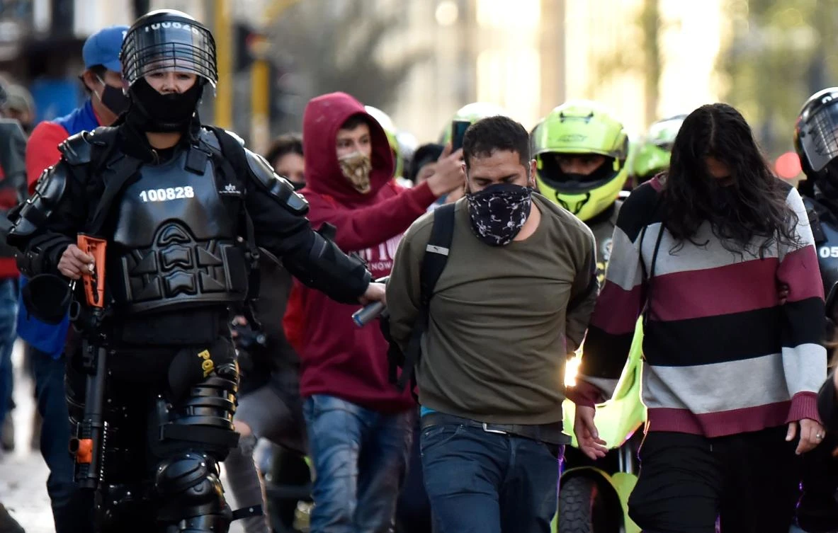 Demonstrators are escorted by riot police after being detained during clashes which erupted in a protest against police brutality in Bogota on September 21, 2020. (AFP)
