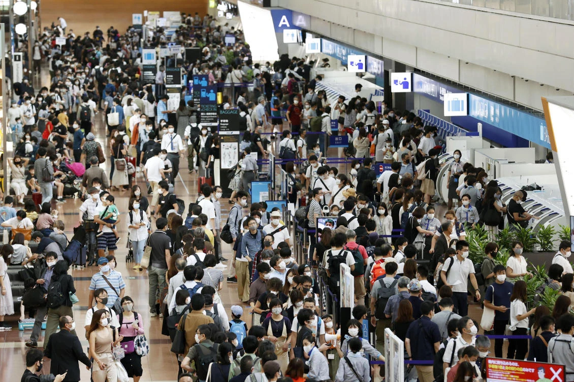 Travelers wearing face masks crowd at Haneda airport in Tokyo Saturday, Sept. 19, 2020, on the first day of the 4-day holiday. (AP)